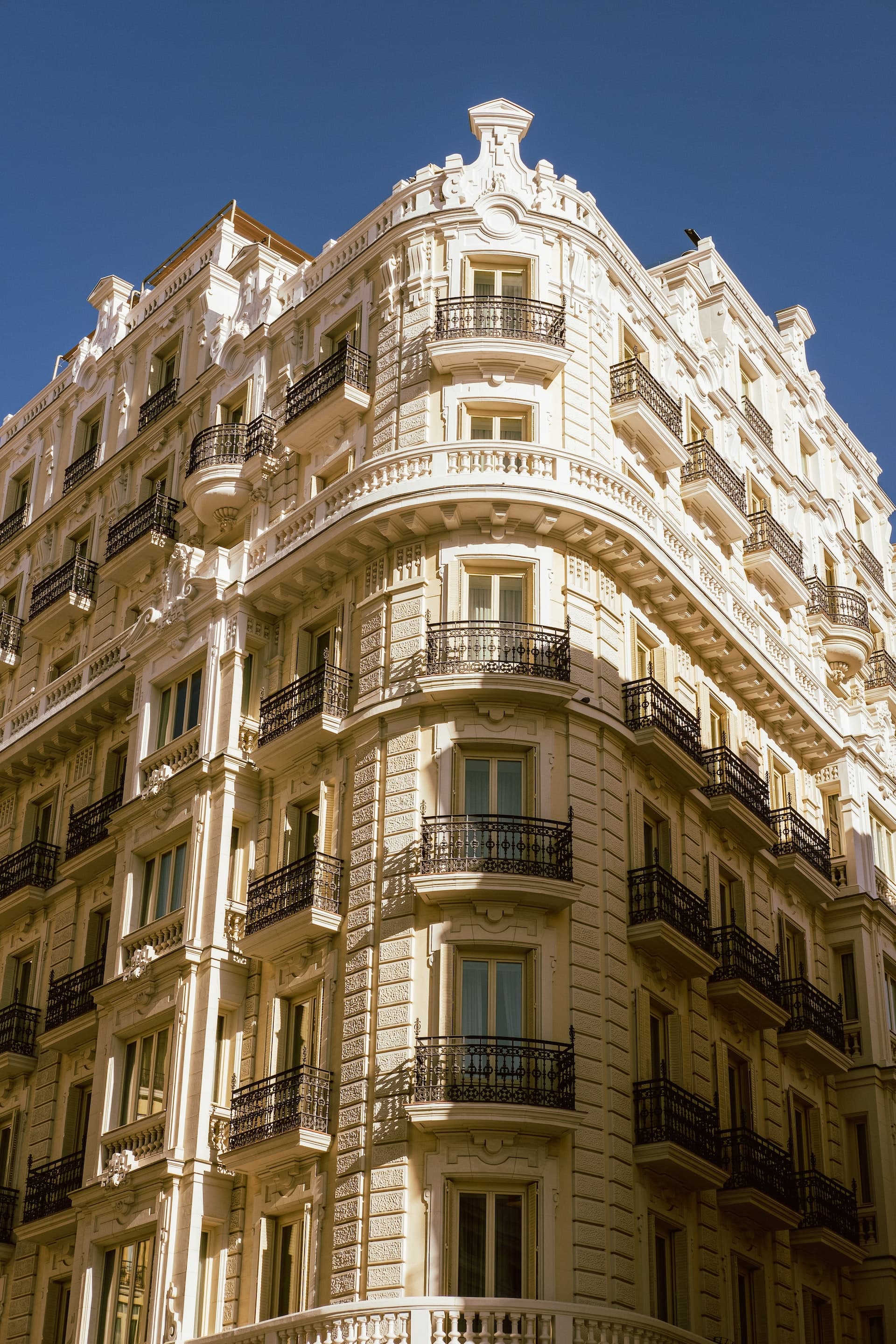 Large white building on the corner of a street.